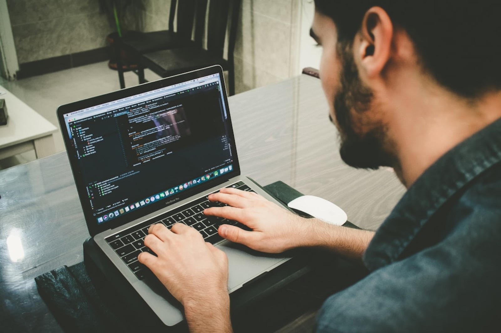 Développeur qui travaille sur du code affiché à l'écran, dans un bureau